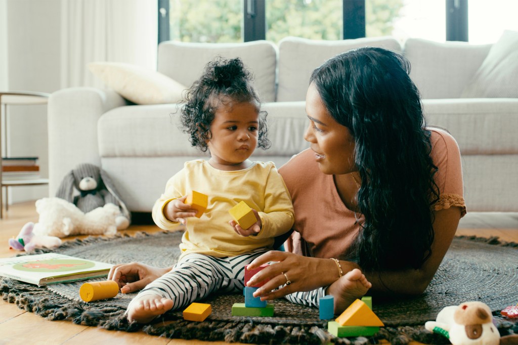 A woman and a child playing with blocks